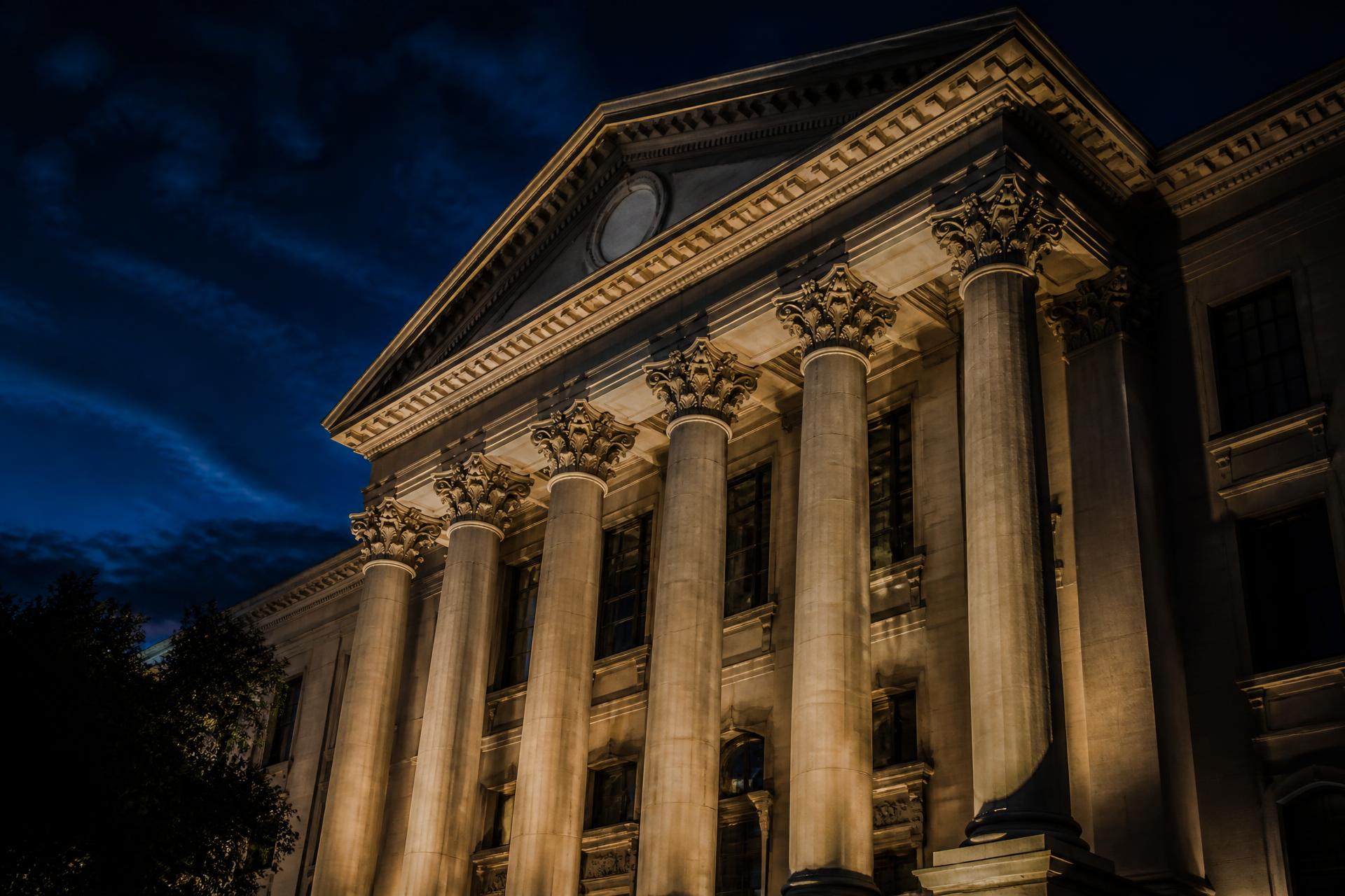 Illuminated courthouse colonnade at dusk